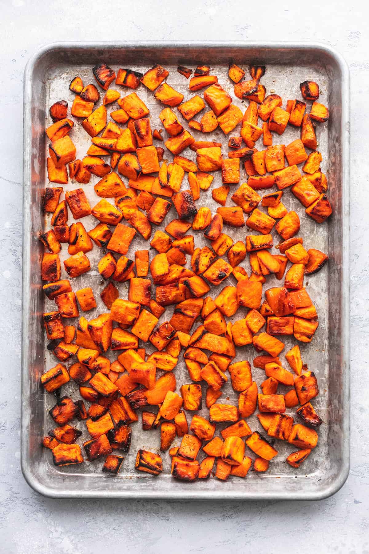 top view of roasted sweet potatoes on a baking sheet.