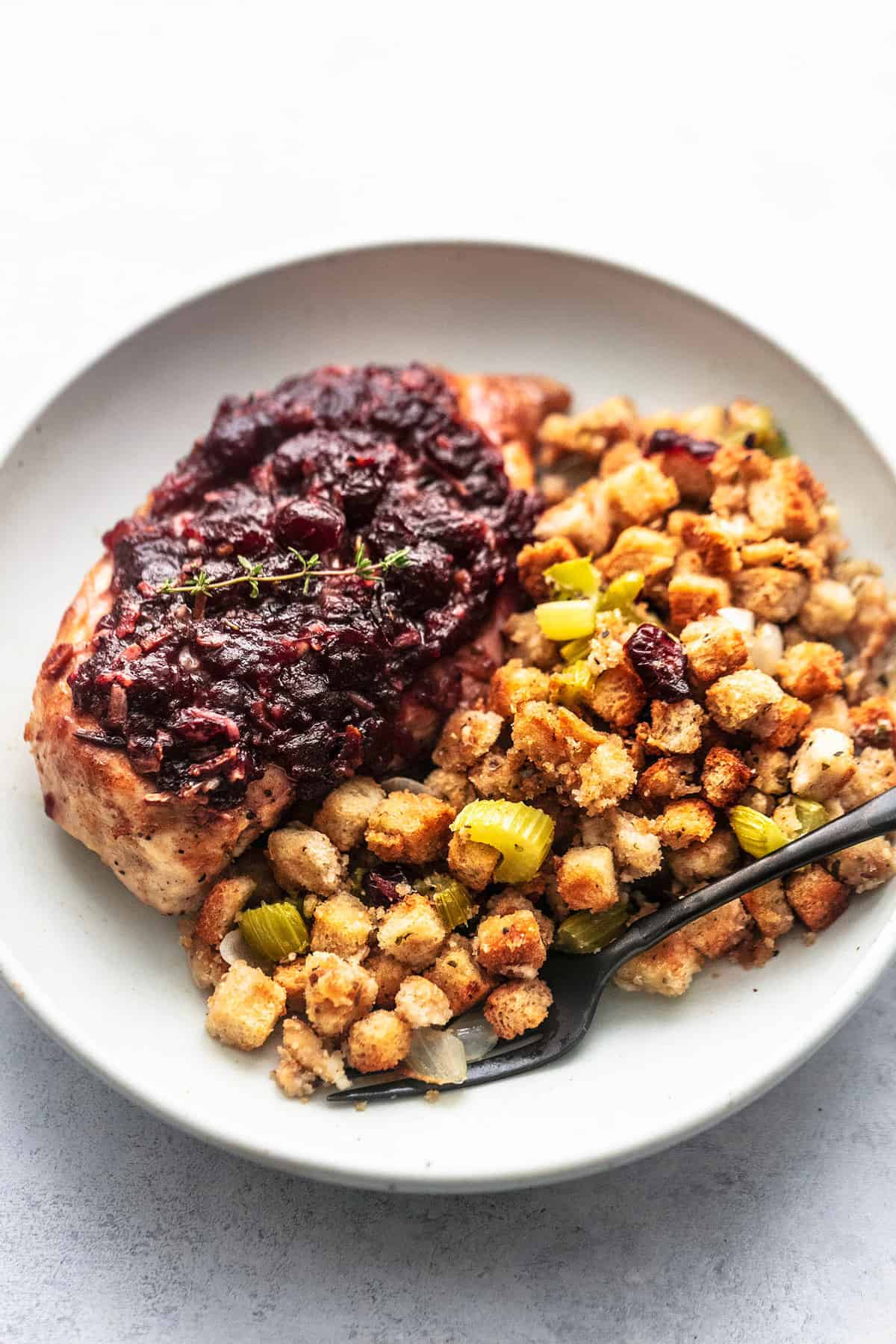 sheet pan cranberry chicken and stuffing with a fork on a plate.
