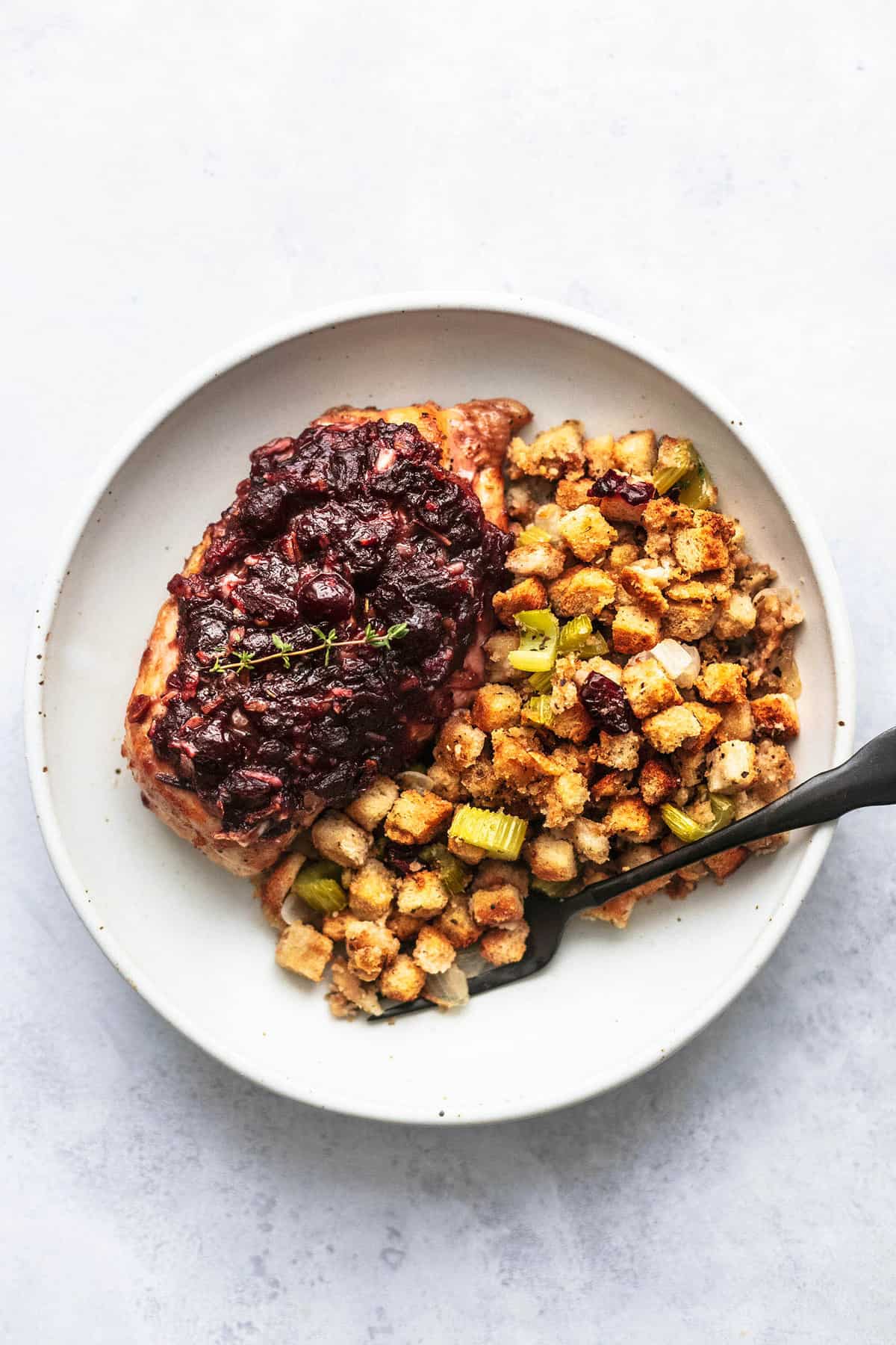 top view of sheet pan cranberry chicken and stuffing with a fork on a plate.