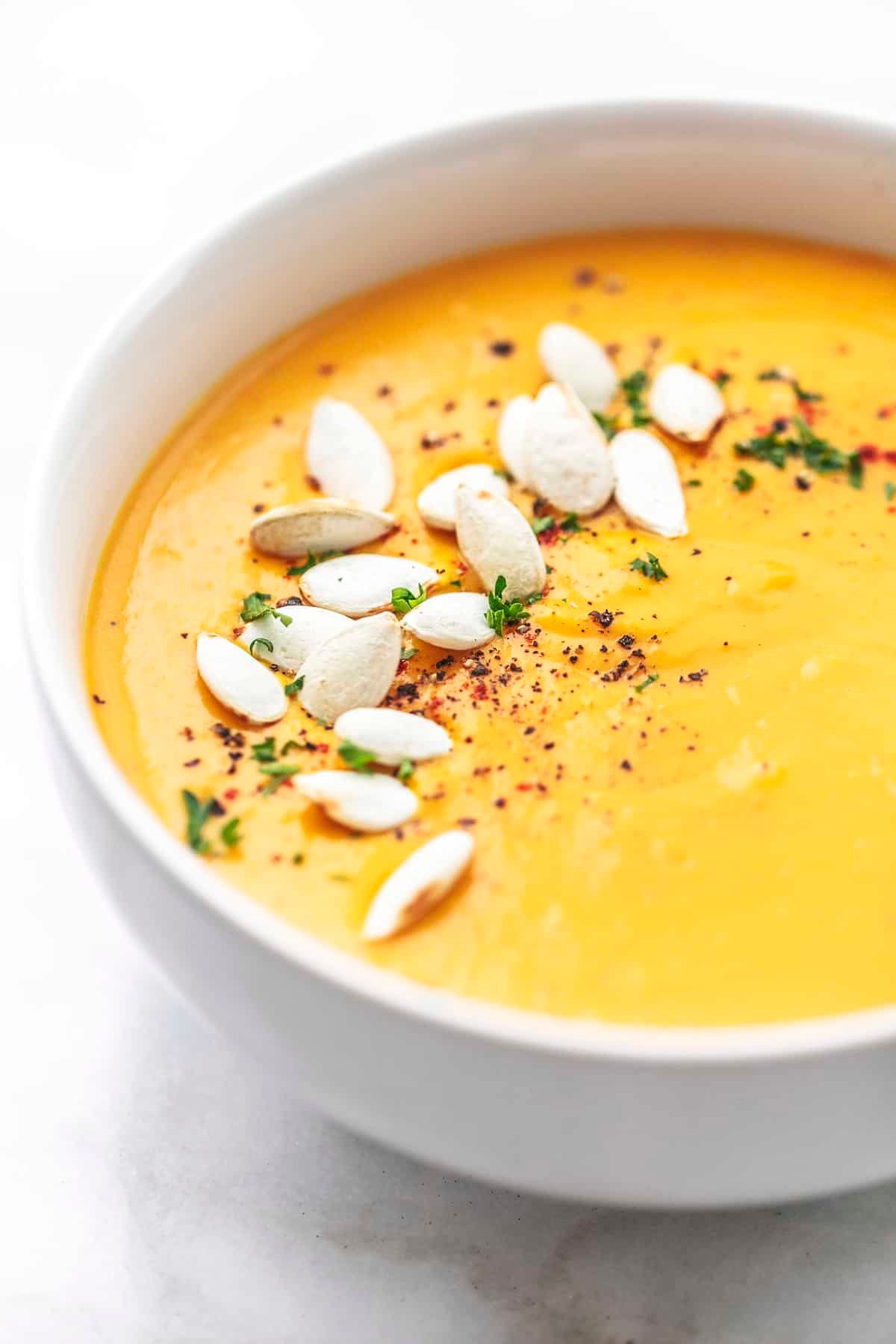 close up of creamy butternut squash soup in a bowl.