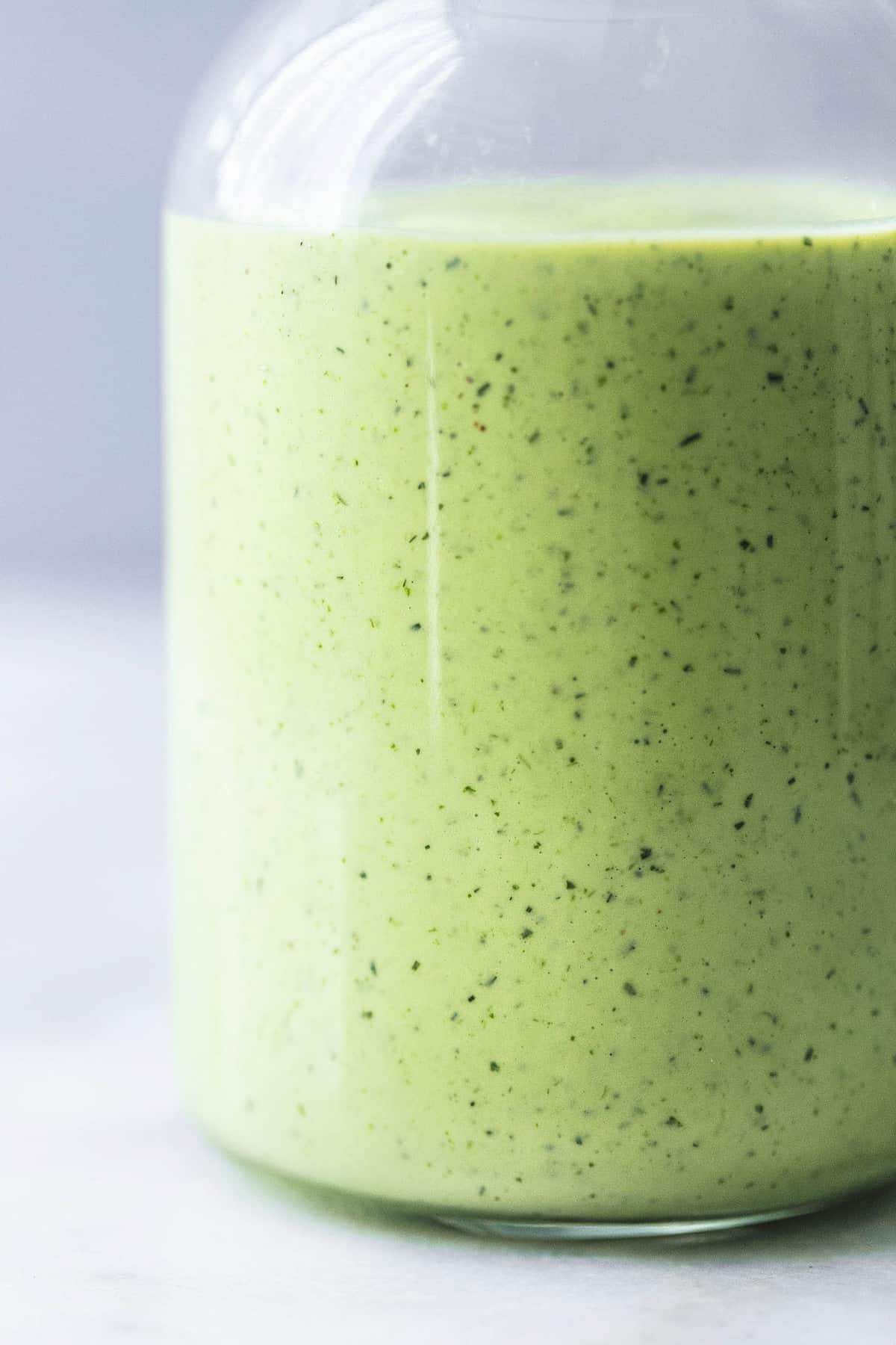 close up of cilantro avocado ranch dressing in a jar.