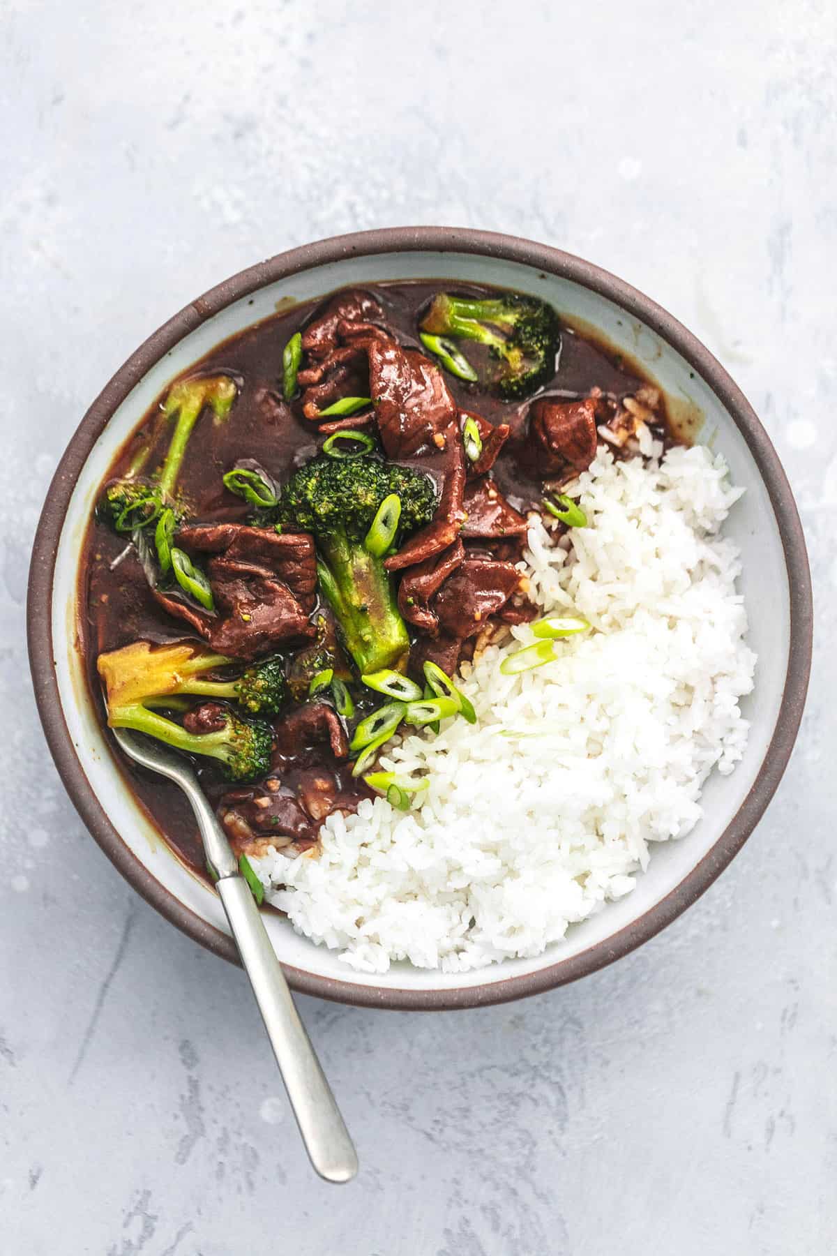 top view of beef and broccoli with rice in bowl with a fork.