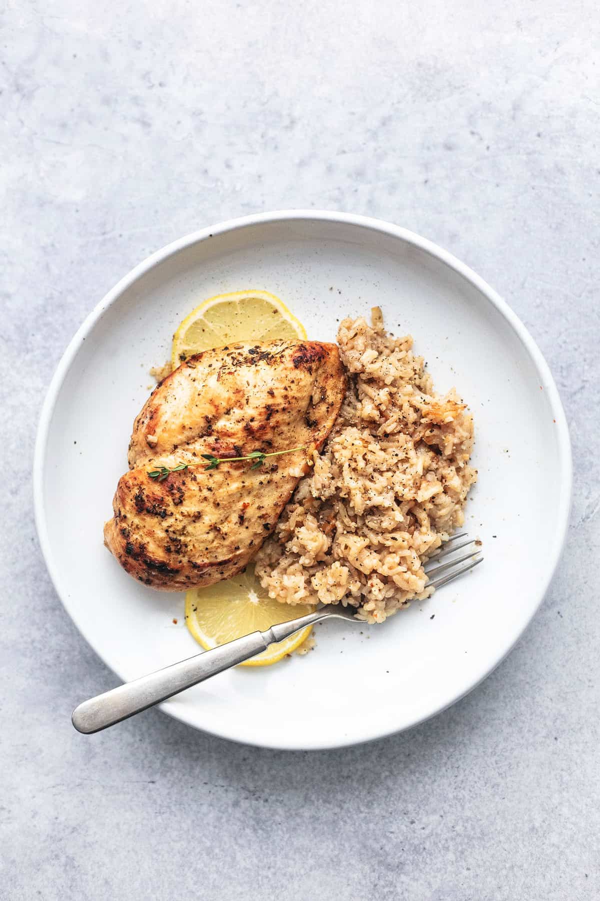 top view of instant pot chicken breast and rice with a fork on a plate.