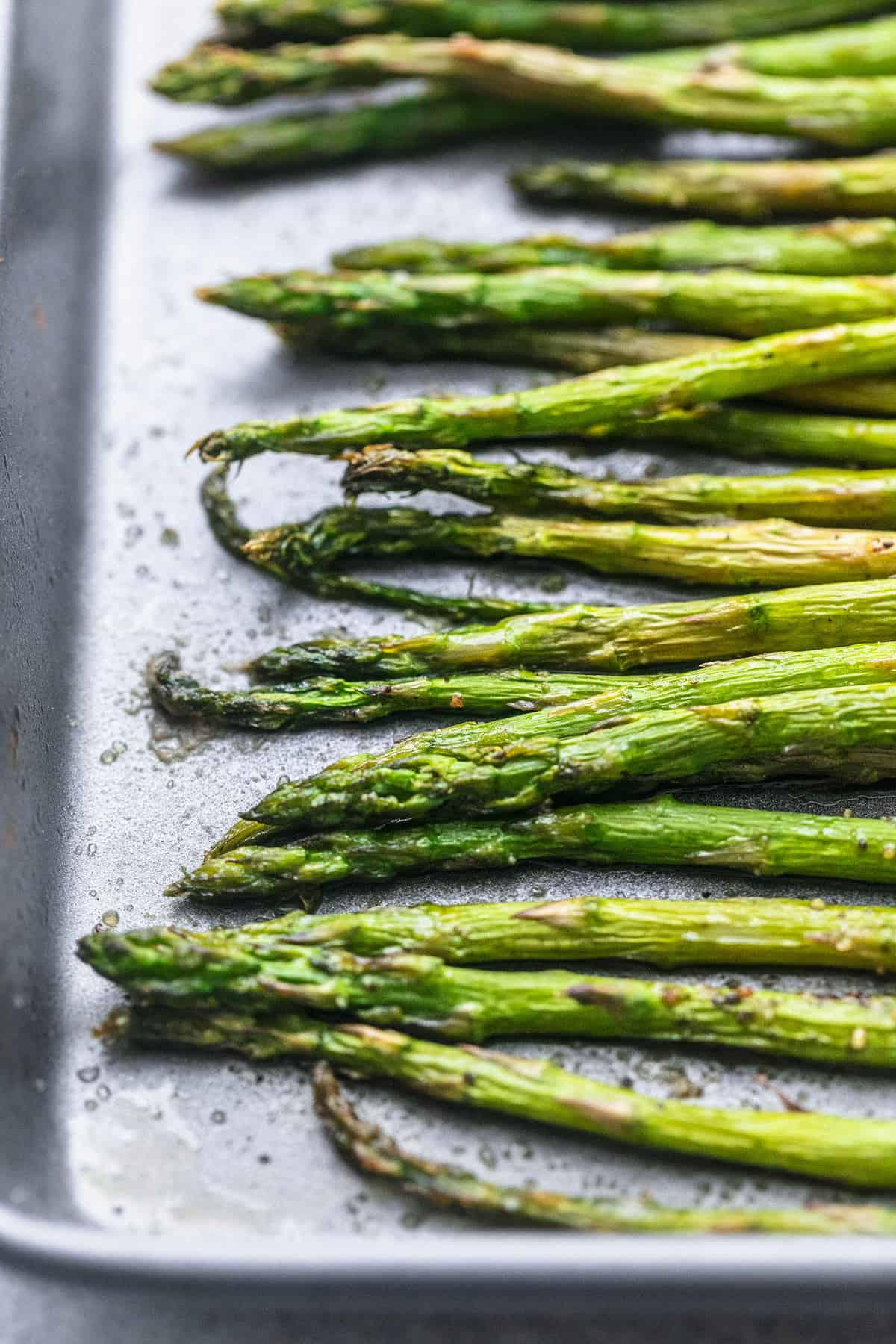 close up of roasted asparagus on a baking sheet.