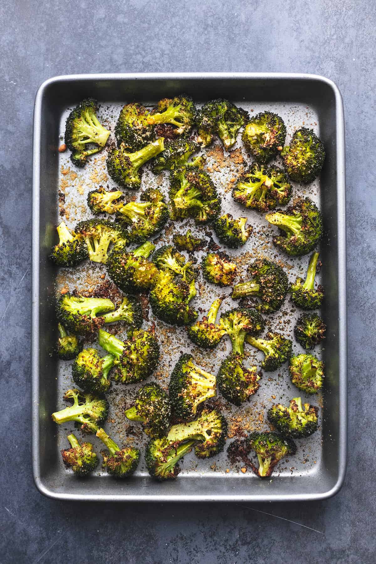 top view of roasted broccoli on a baking sheet.