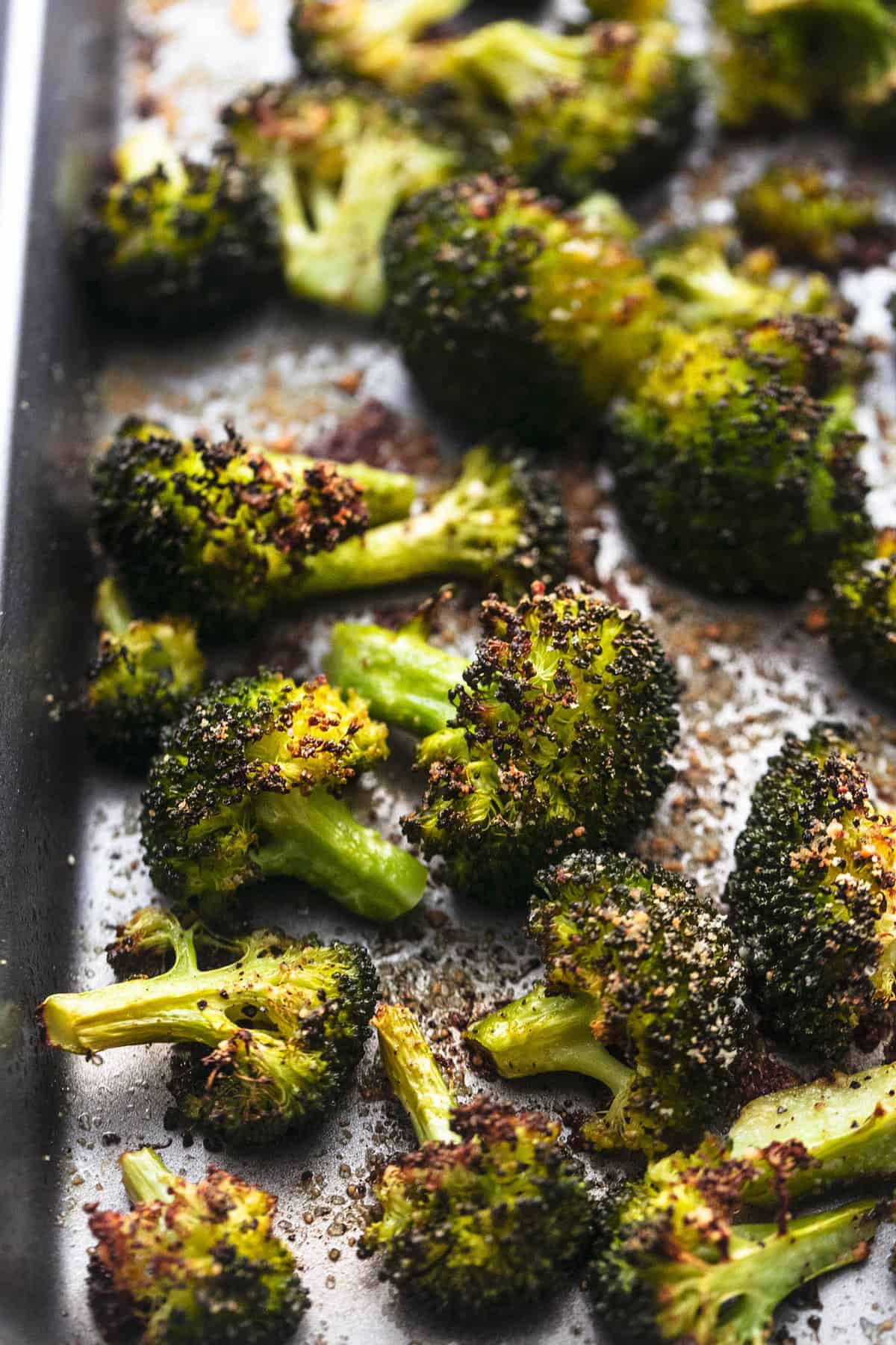 close up of roasted broccoli on a sheet pan.