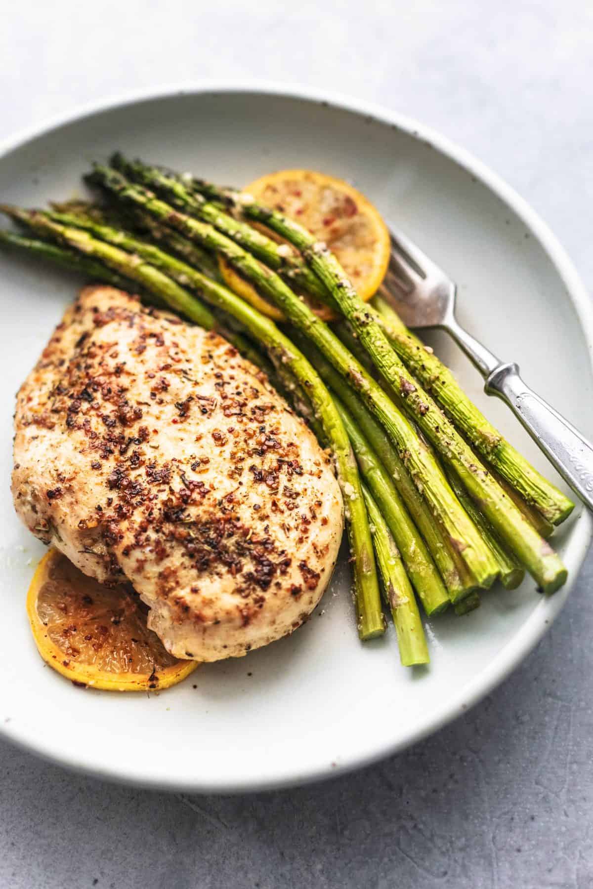 sheet pan chicken and asparagus with a fork on a plate.