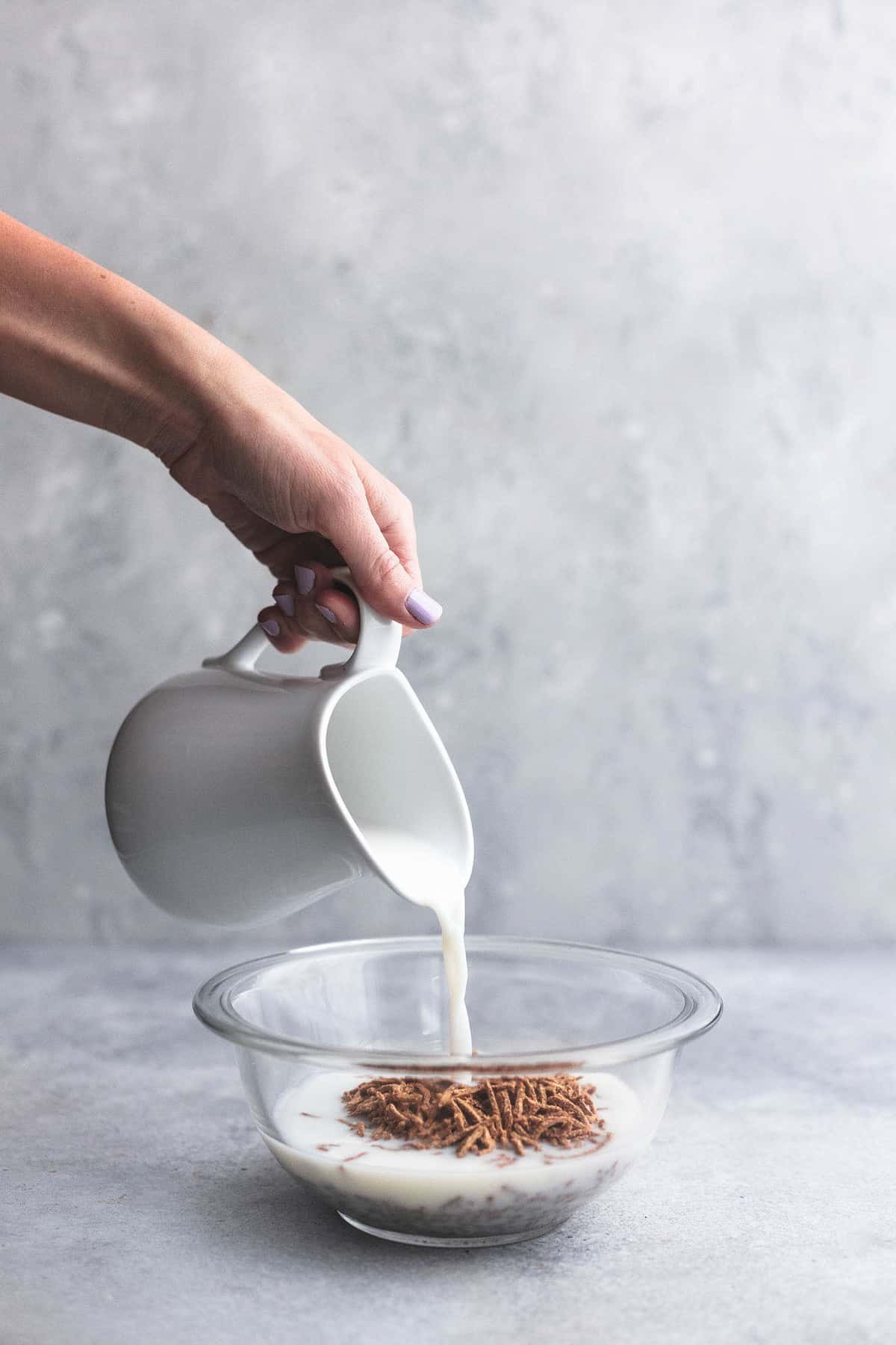 milk being poured into a bowl of bran cereal