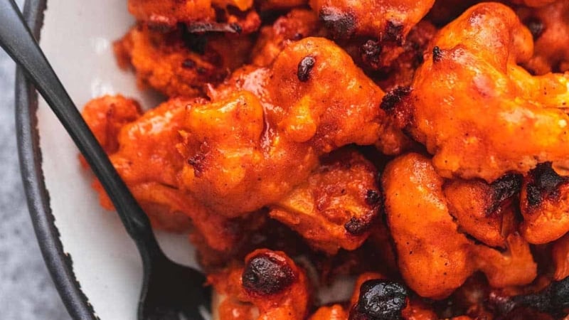 up close buffalo cauliflower on a plate with a fork