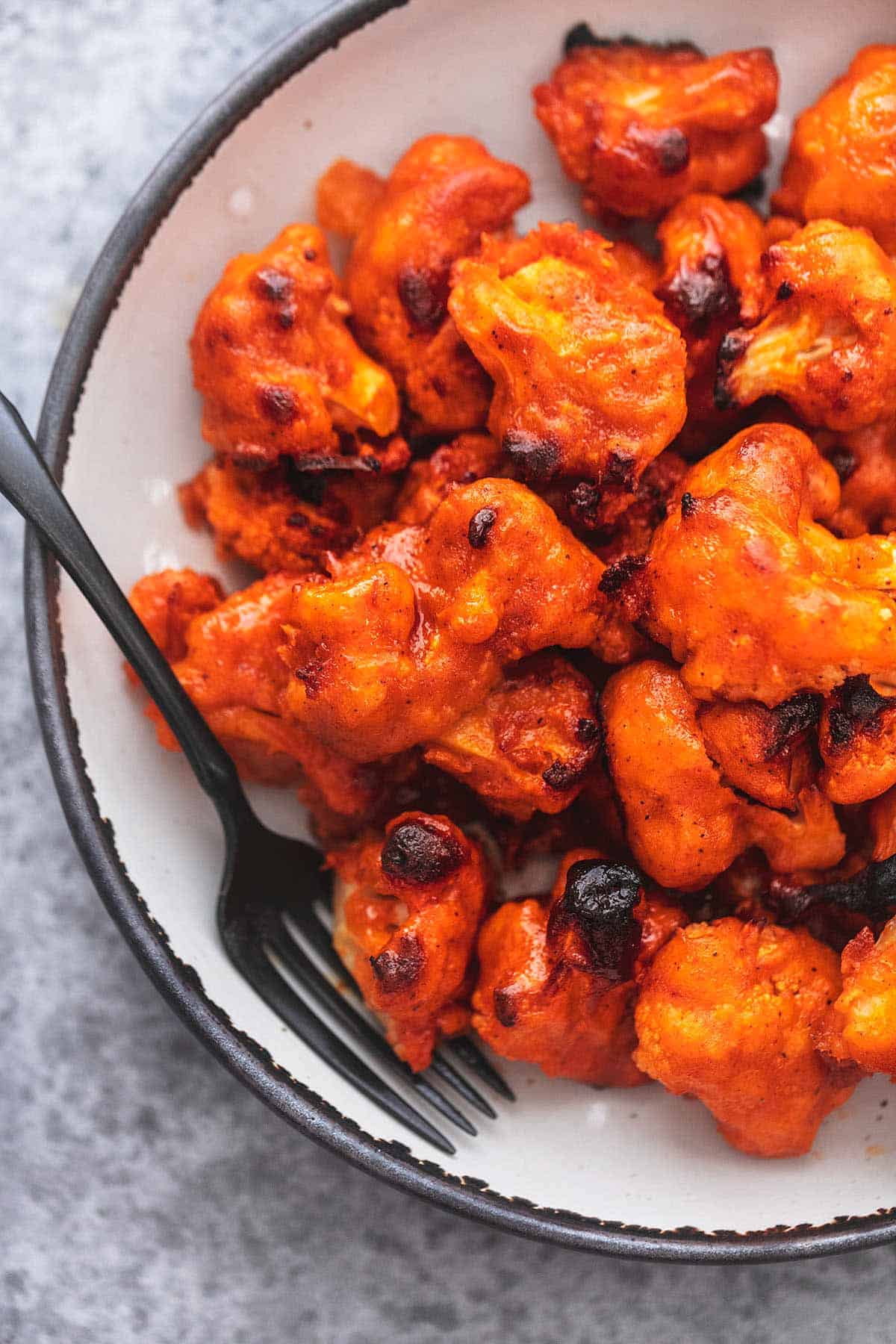 up close buffalo cauliflower on a plate with a fork