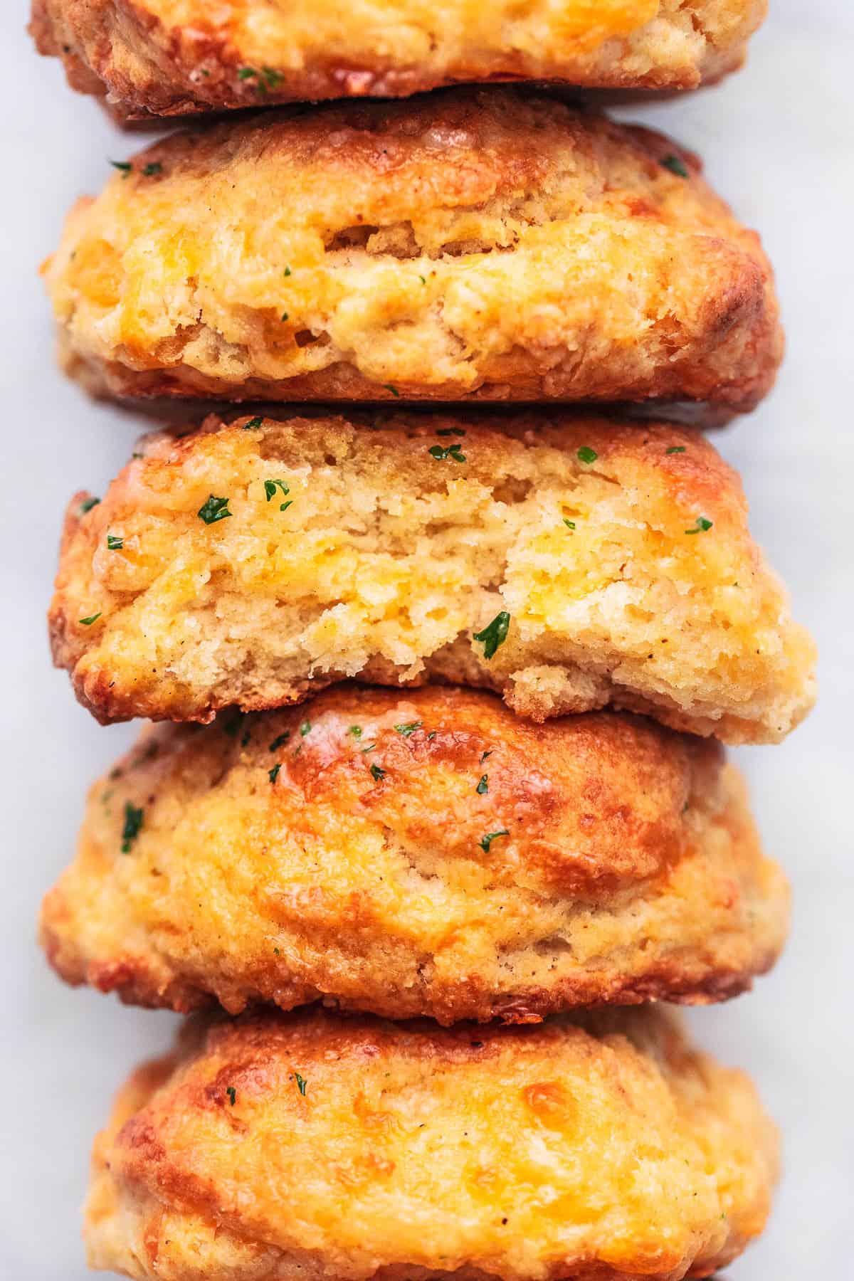 close up of red lobster cheddar bay biscuits stacked on white surface.