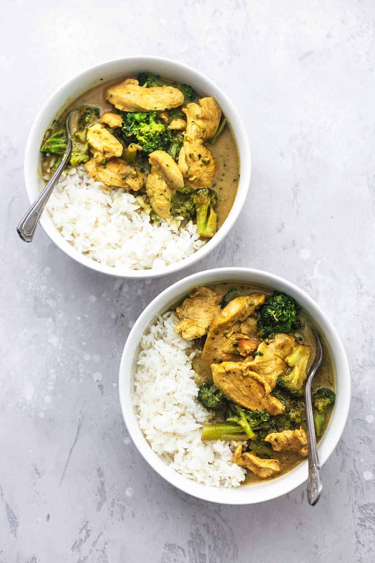 top view of chicken and broccoli coconut curry in two bowls.