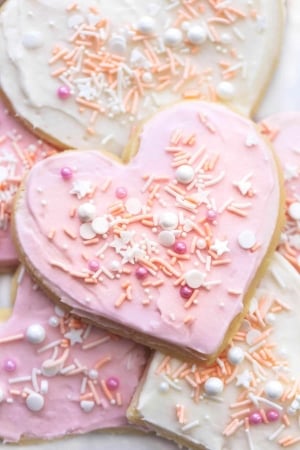 up close heart shaped sugar cookie with pink frosting and sprinkles