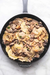 mushroom ravioli with creamy sauce in a skillet