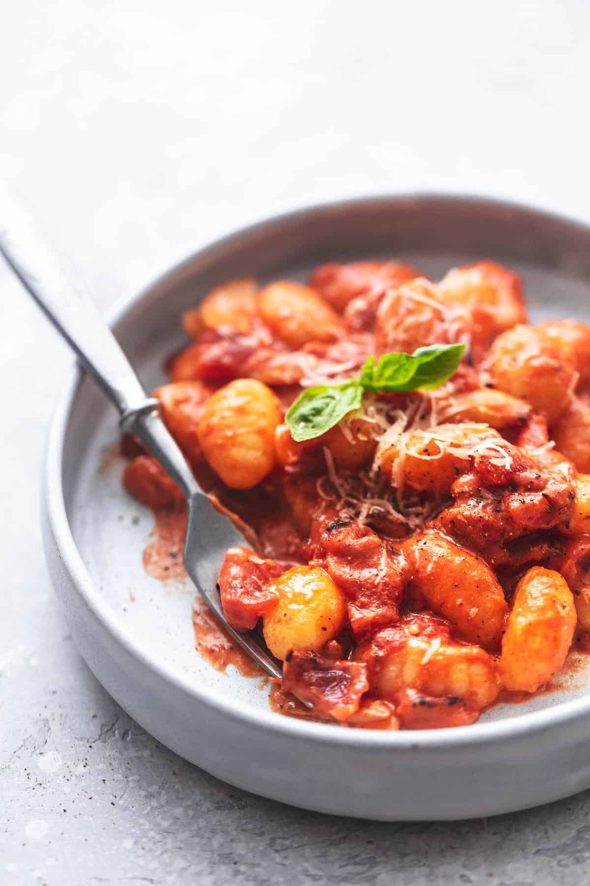 gnocchi with creamy tomato sauce on a gray plate with a fork
