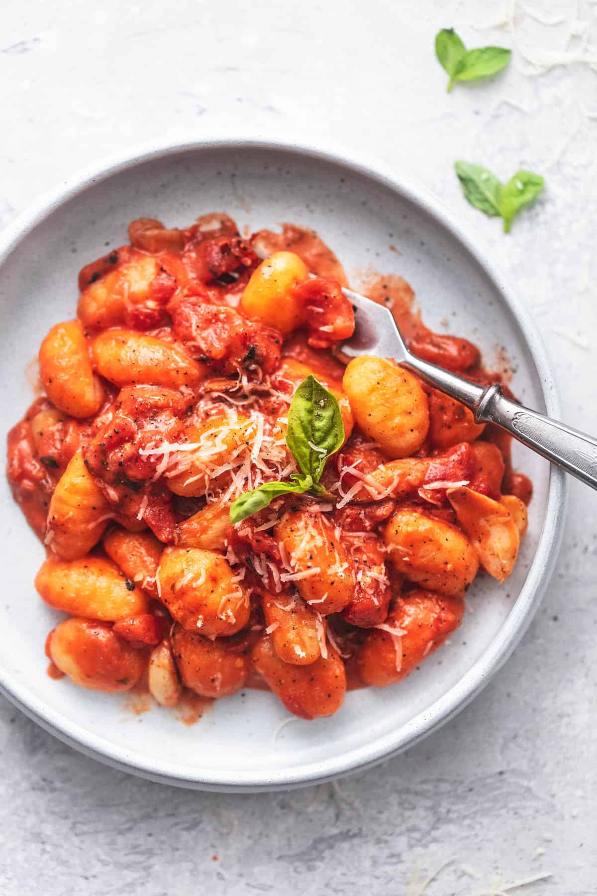 gnocchi and tomato sauce up close in a gray dish