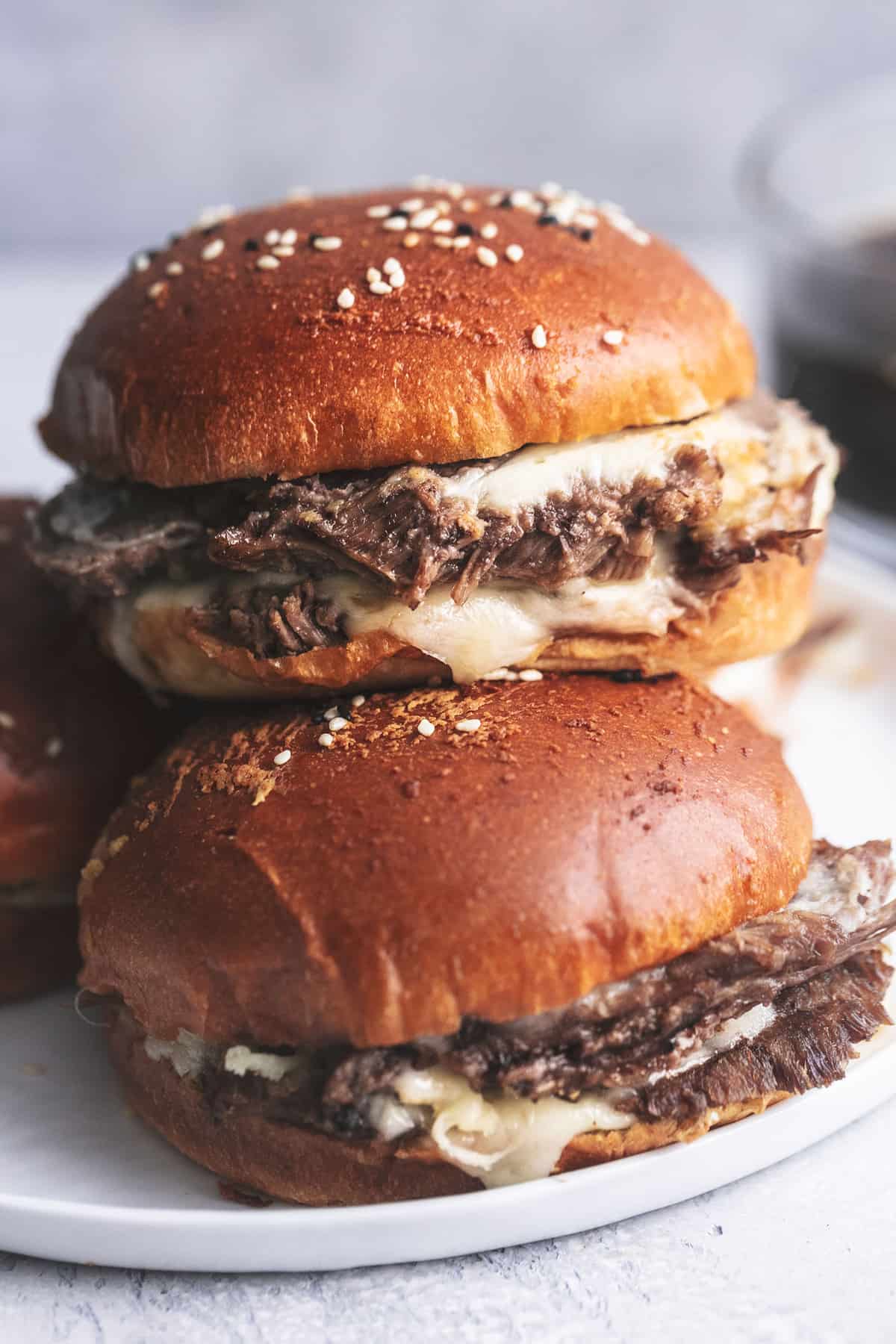 close up of french dip sandwiches on a plate.