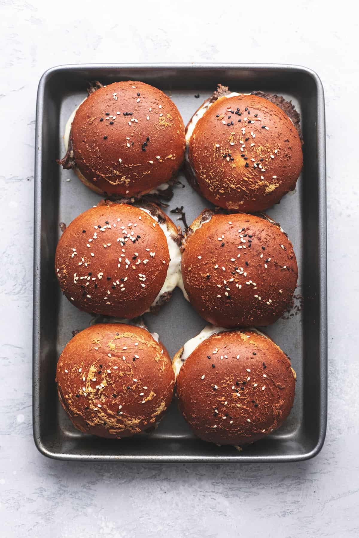 top view of french dip sandwiches on a baking sheet.