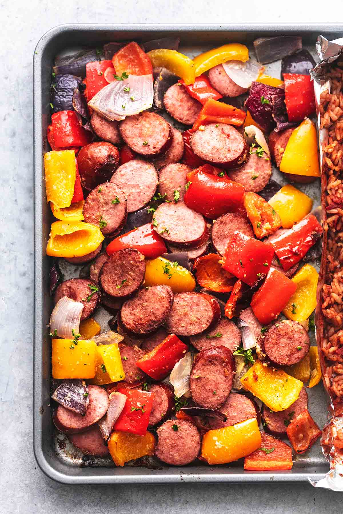 close up top view of sheet pan sausage and veggies on a sheet pan.