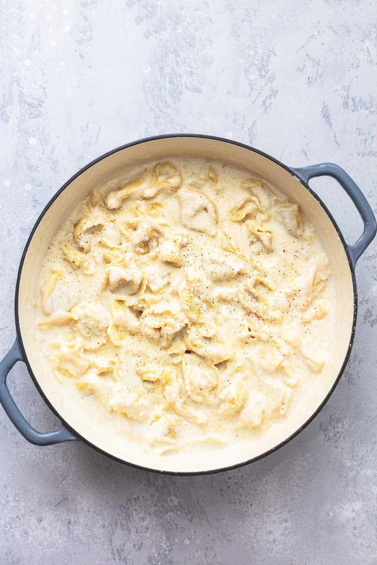 top view of tortellini alfredo in a skillet.