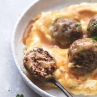 up close bite of meatball on a fork with gravy