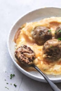 up close bite of meatball on a fork with gravy