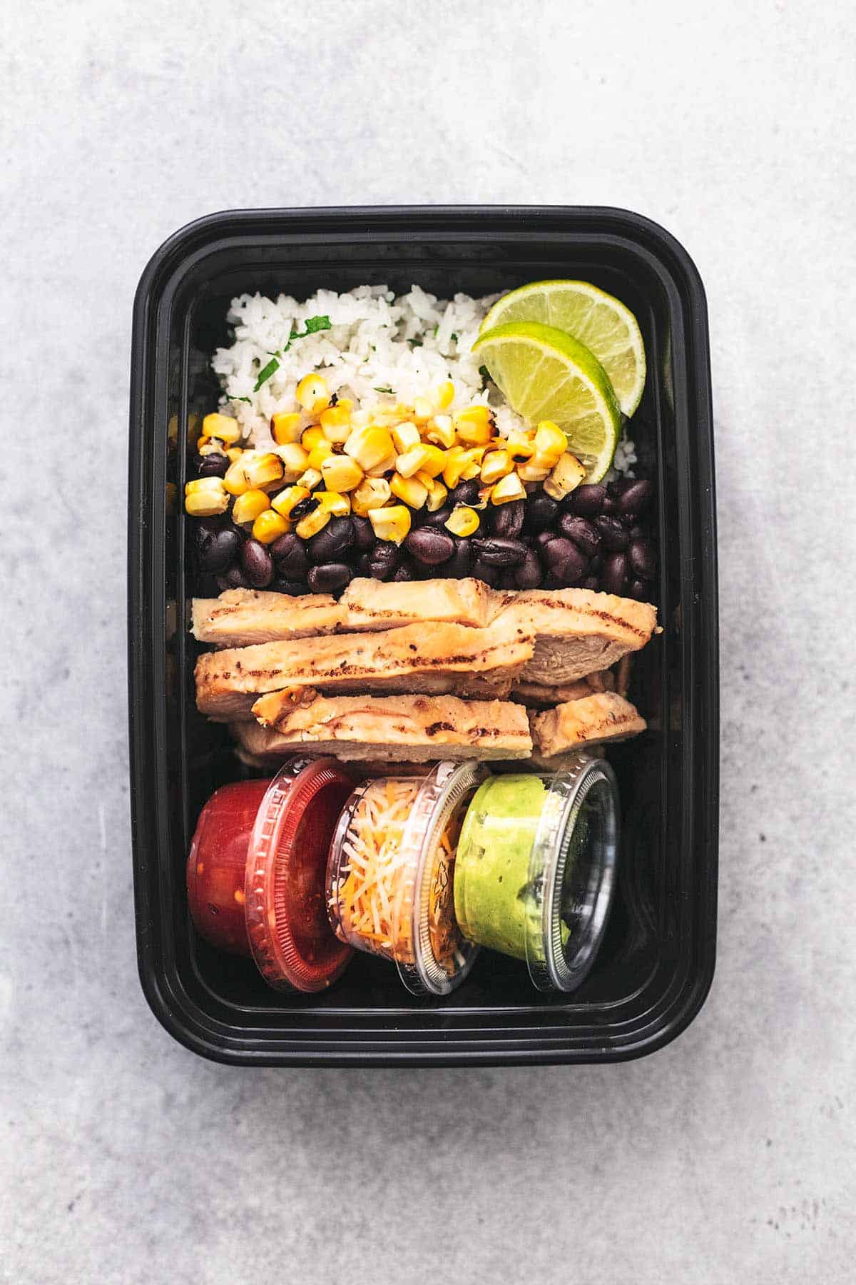 top view of a chicken burrito bowl in a meal prep container.