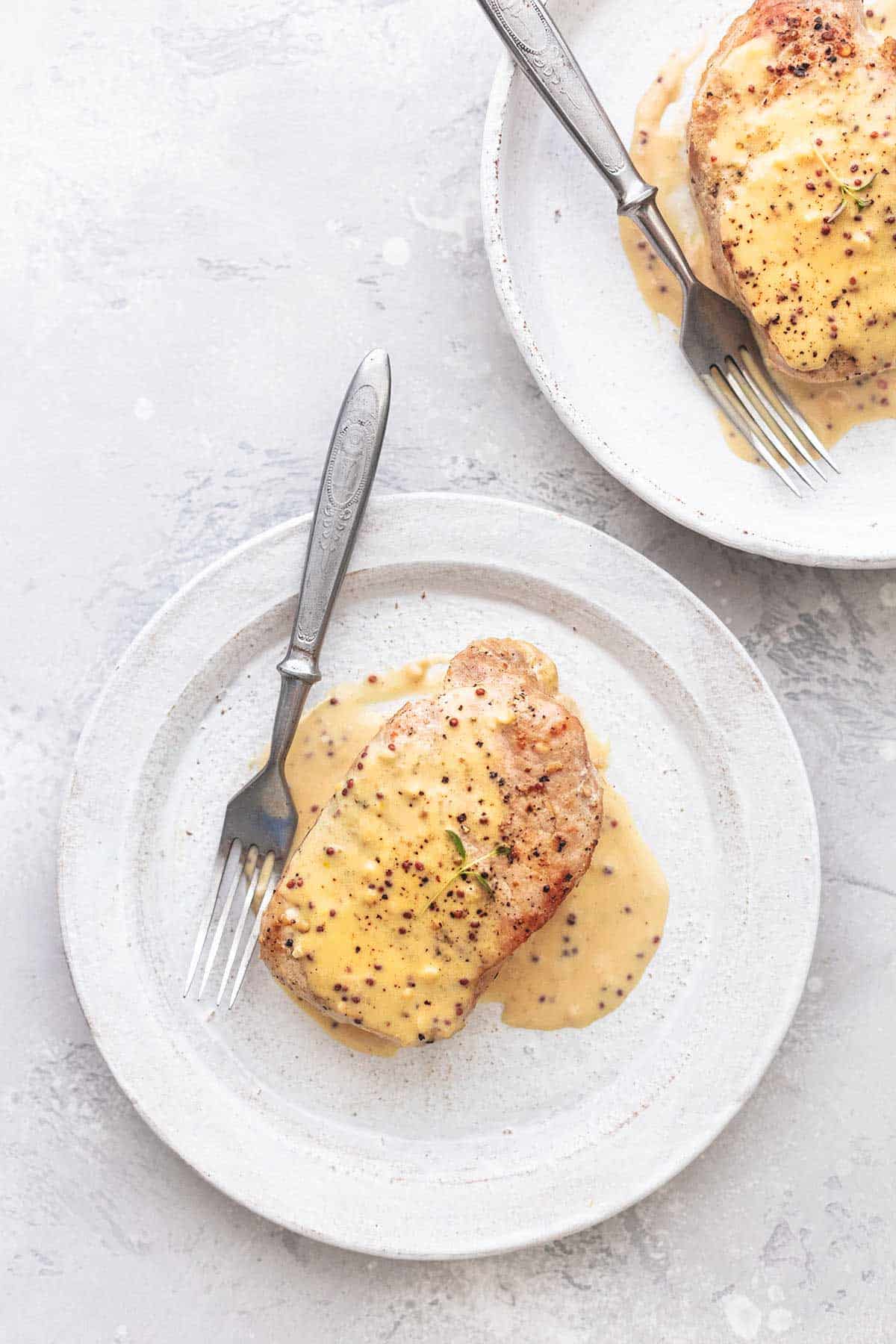 pork chops with cream sauce on white plates