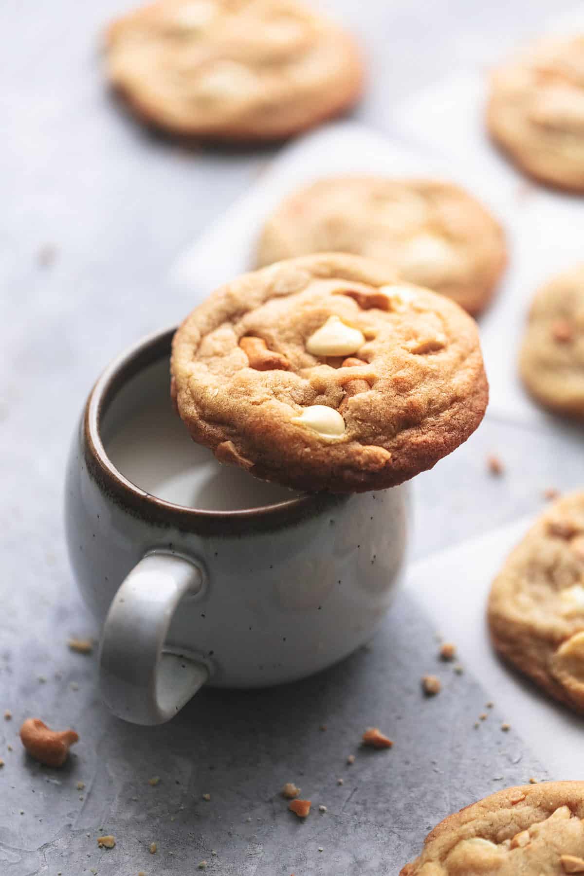 white chocolate and cashew cookie on a cup of milk