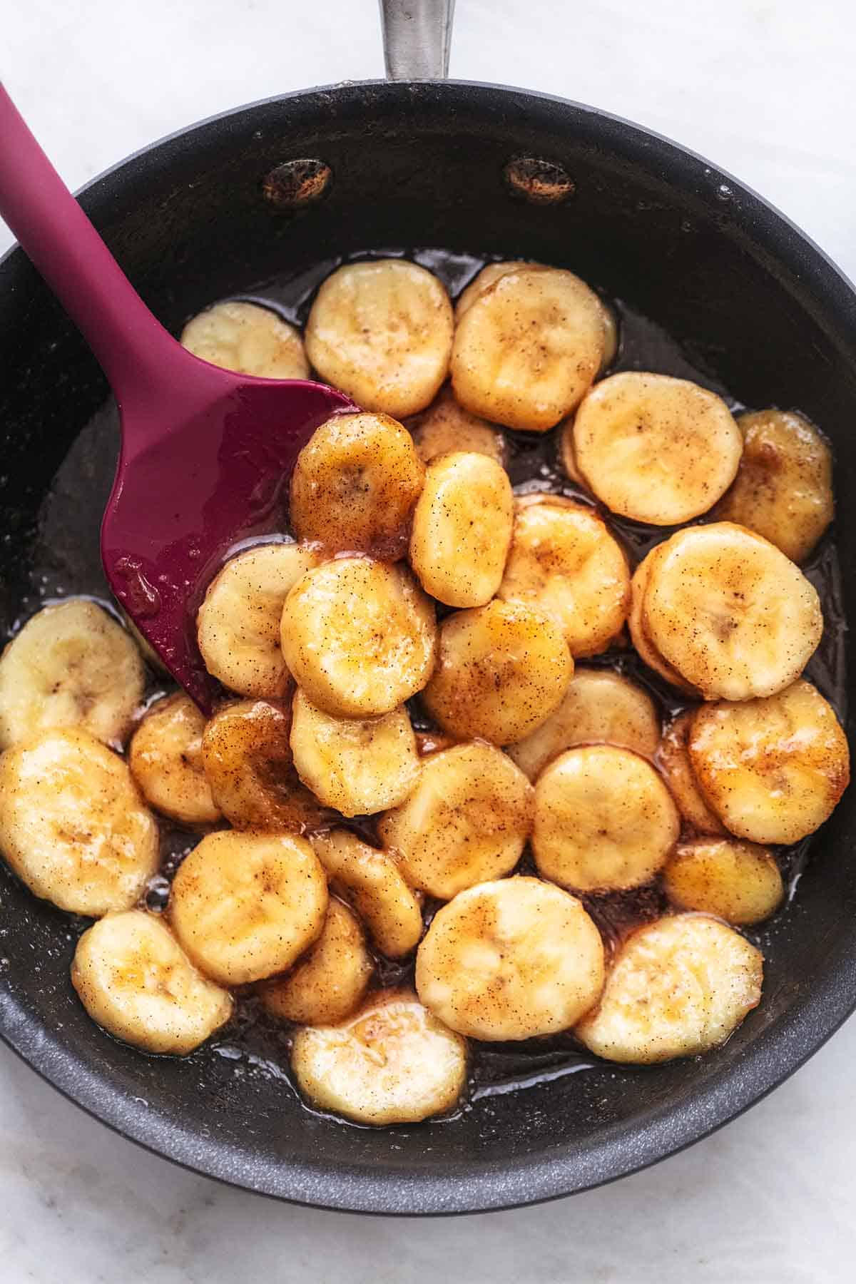top view of caramelized bananas with a spatula in a pan.