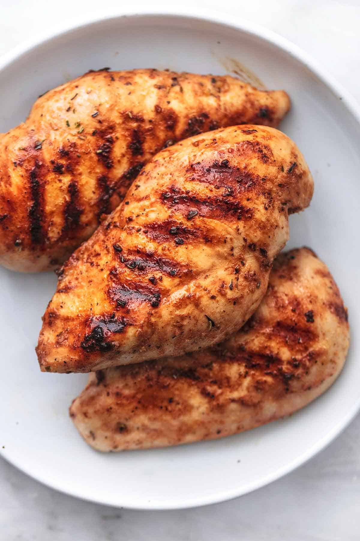 close up top view of grilled chicken on a plate.