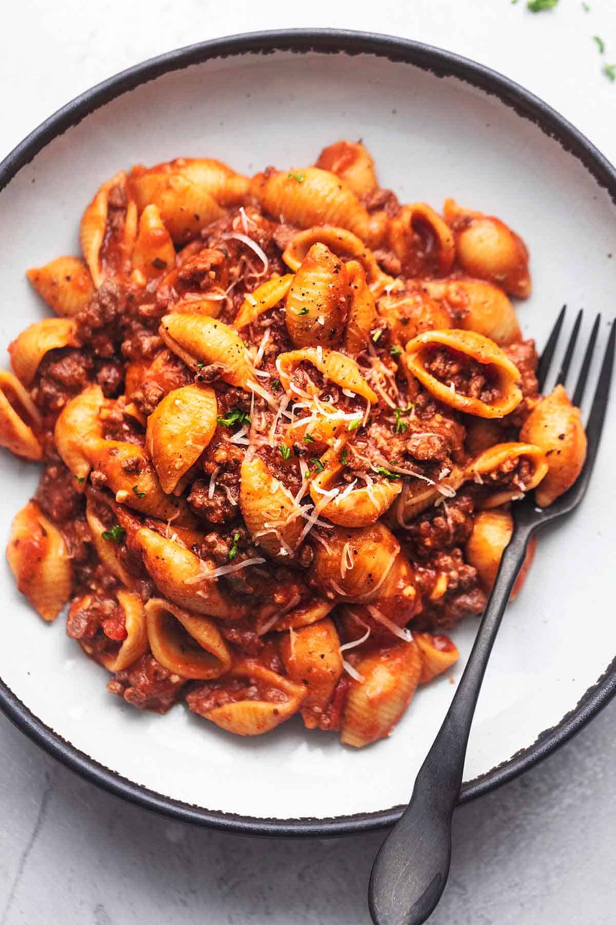 close up top view of instant pot ground beef pasta with a fork on a plate.