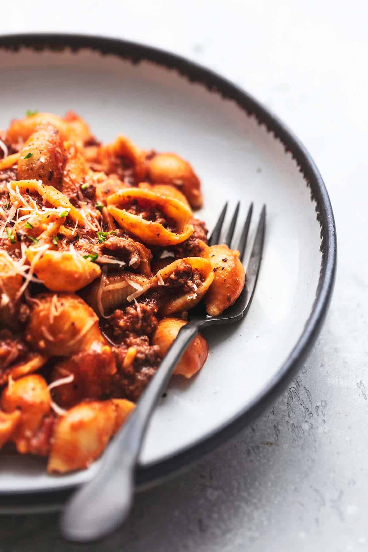 close up of instant pot ground beef pasta with a fork on a plate.