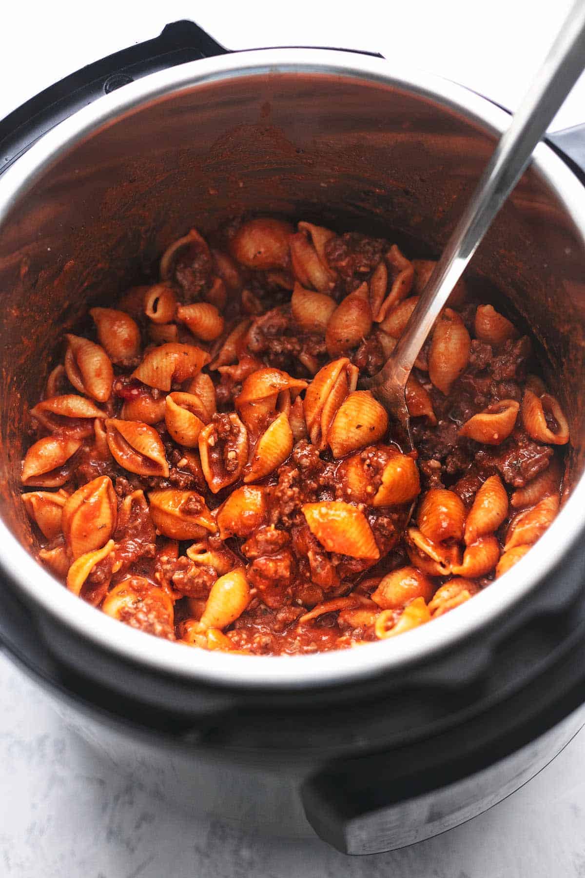 instant pot ground beef pasta with a serving spoon in an instant pot.