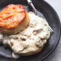 biscuits and sausage gravy with fork on plate