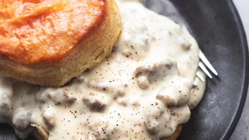 biscuits and sausage gravy with fork on plate
