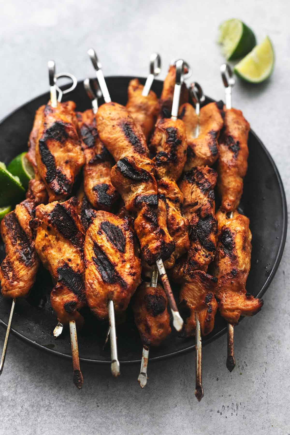 chicken satay skewers on a plate.
