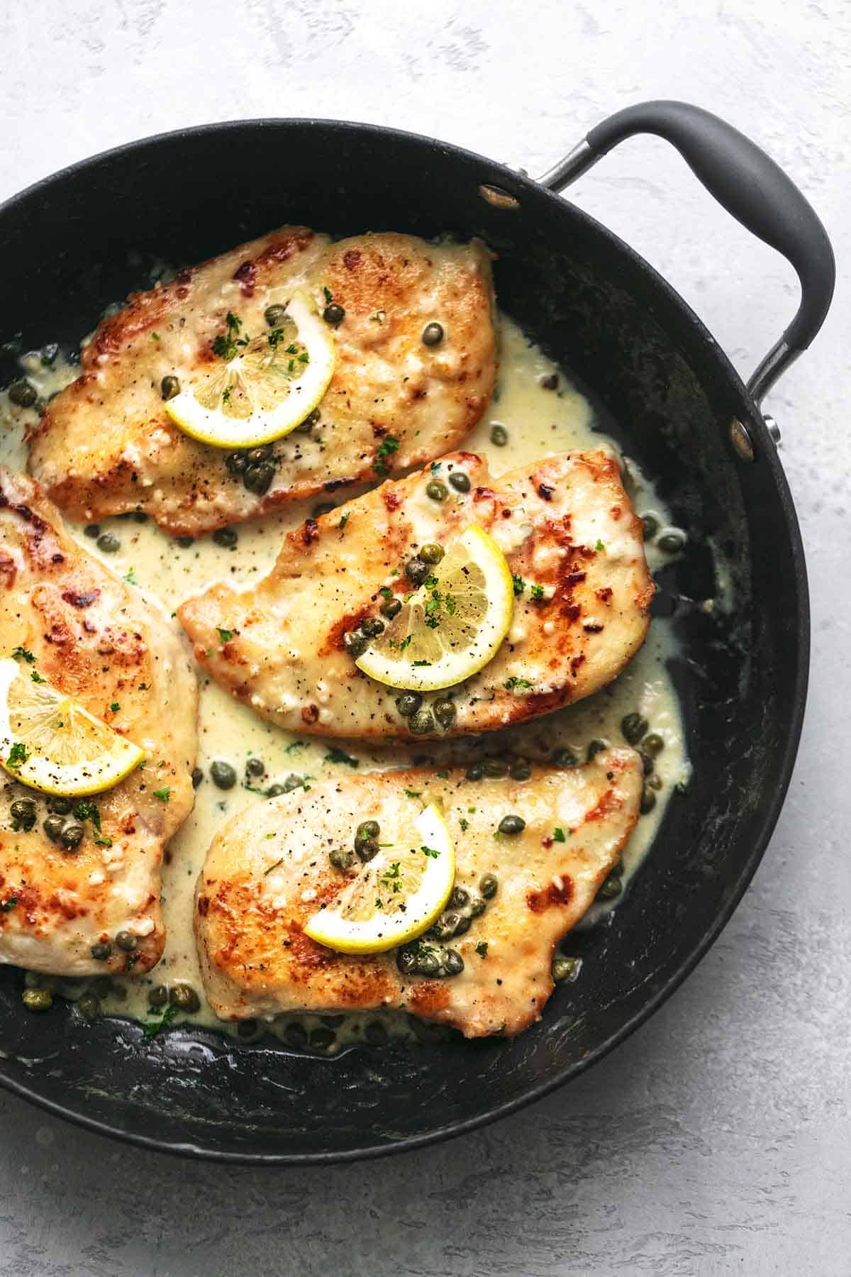 top view of creamy lemon chicken piccata in a skillet.