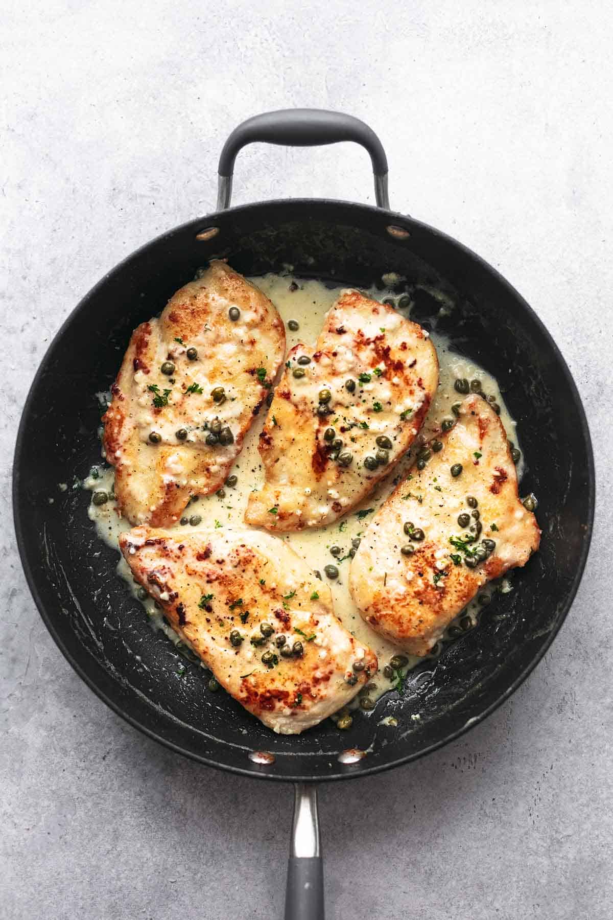 top view of creamy lemon chicken piccata in a skillet.