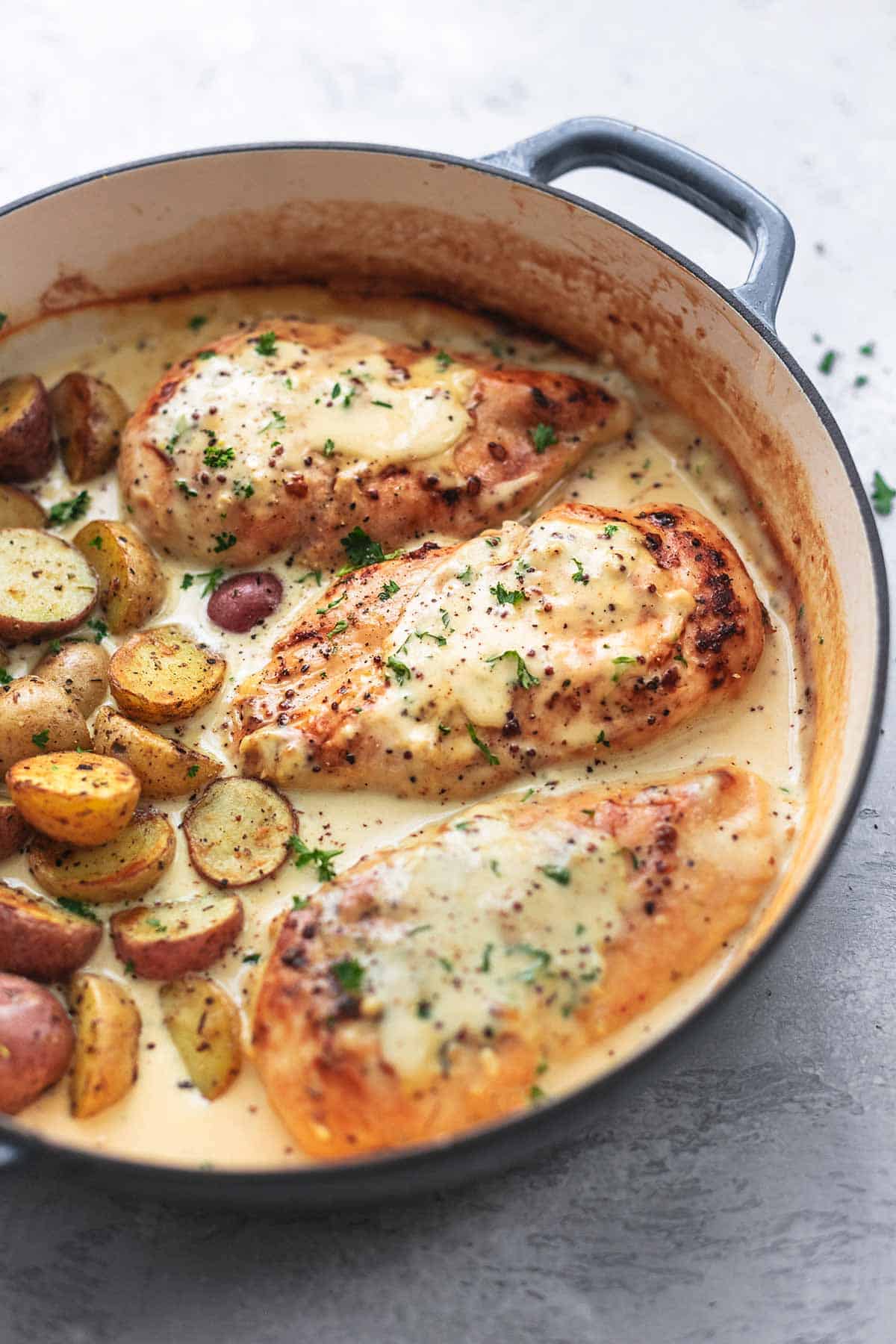 chicken and potatoes with cream sauce in skillet