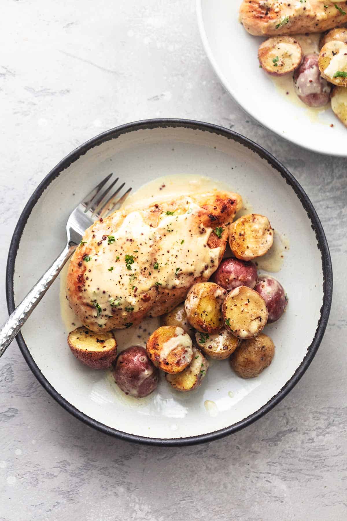 chicken and potatoes on plate with fork overhead