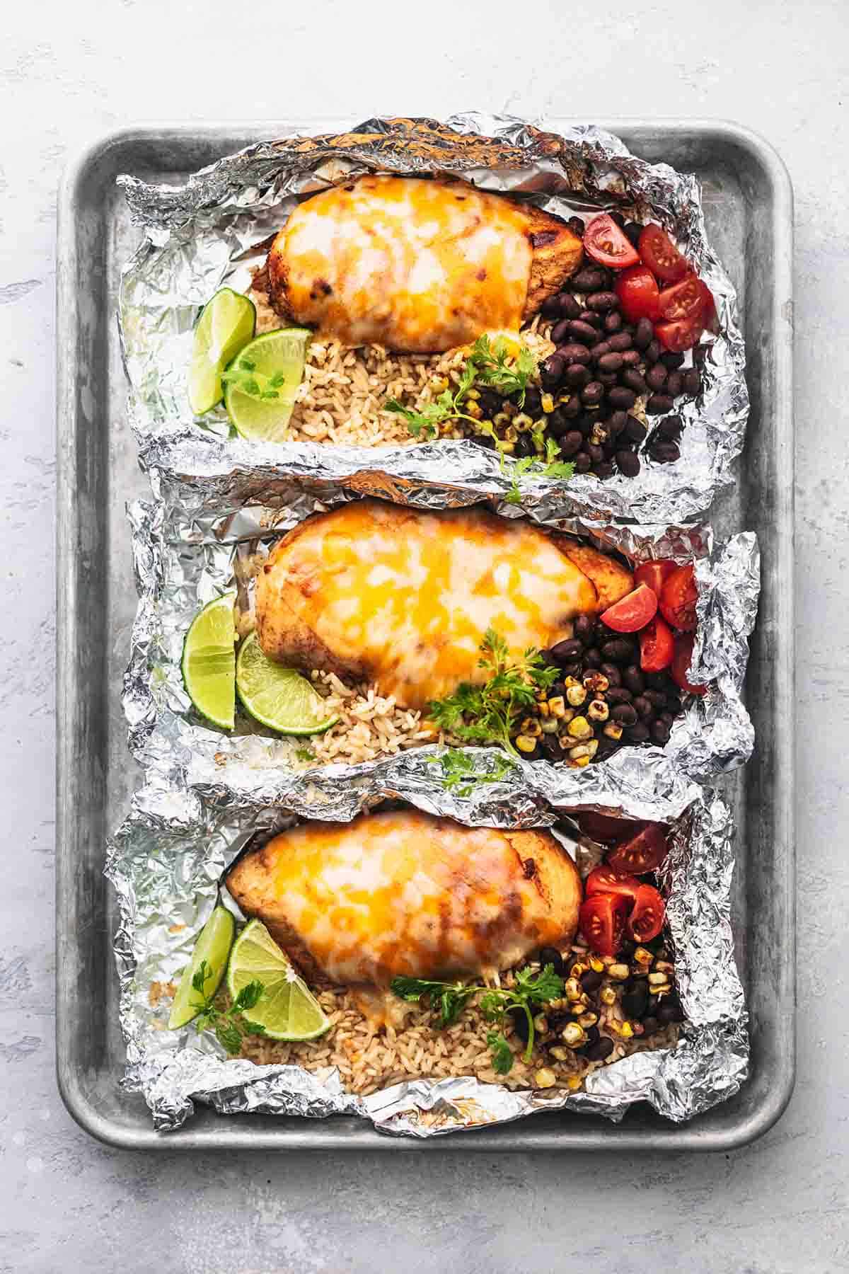 top view of fiesta lime chicken and rice foil packs on a baking sheet.