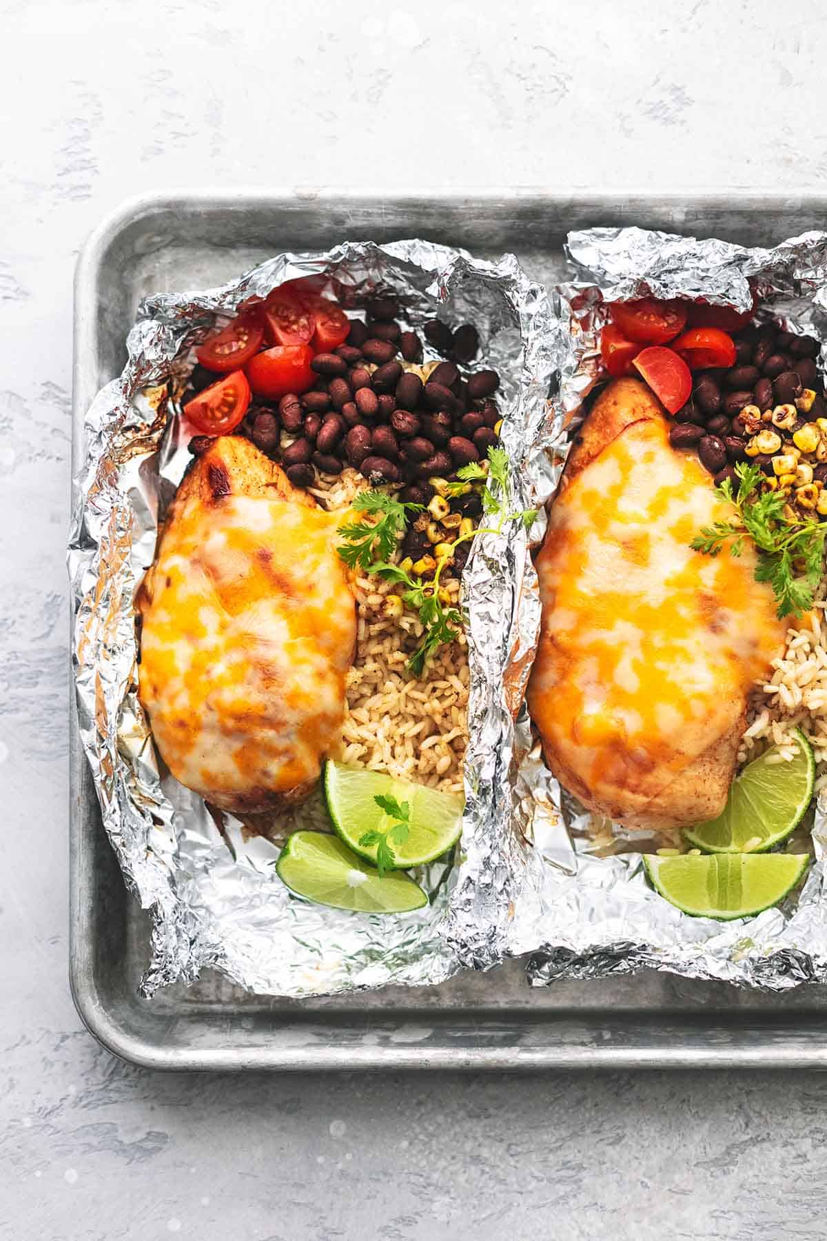 close up of fiesta lime chicken and rice foil packs on a baking sheet.