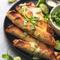 taquitos on plate with sauce and limes