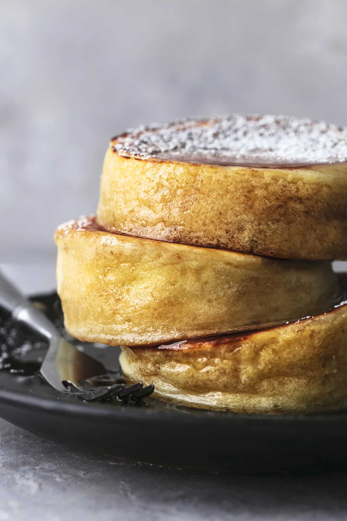 close up of a stacked Japanese soufflé pancakes on a plate with a fork.