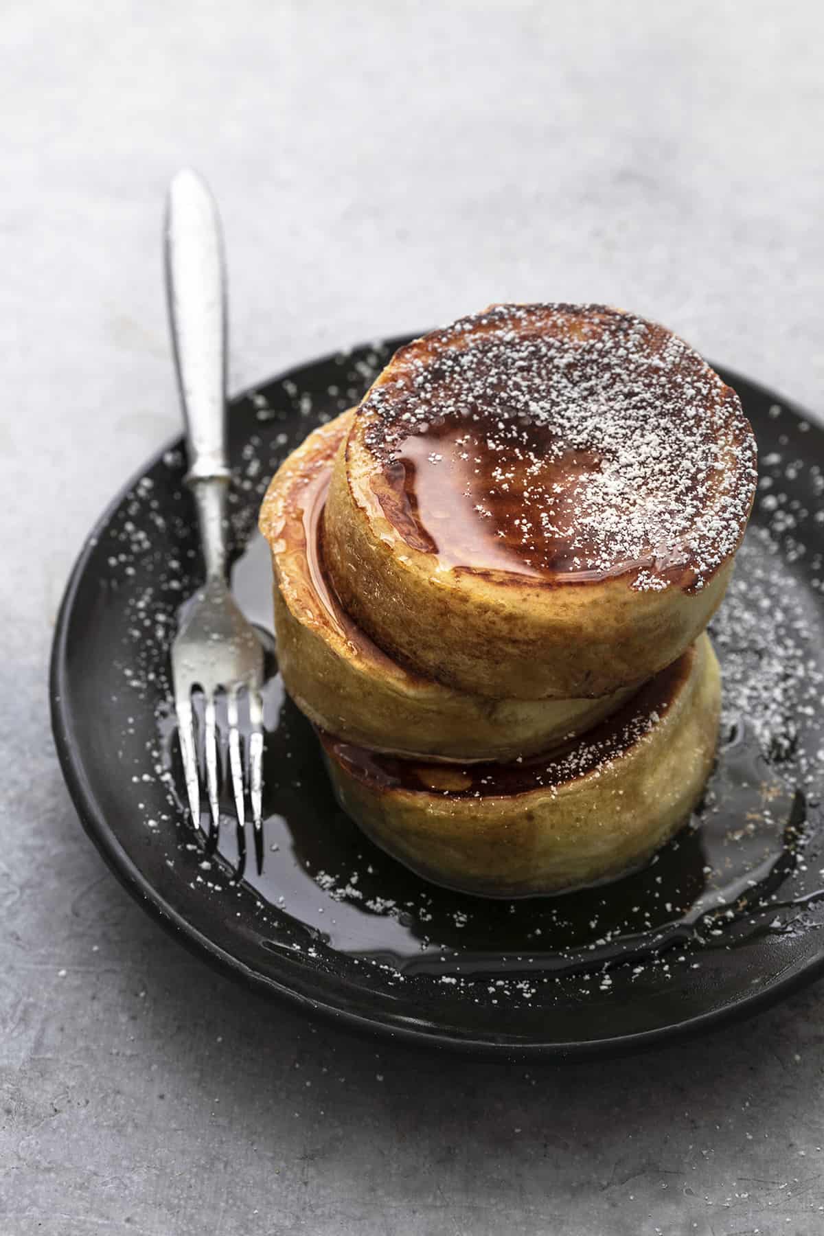 a stack of Japanese soufflé pancakes on a plate with a fork.