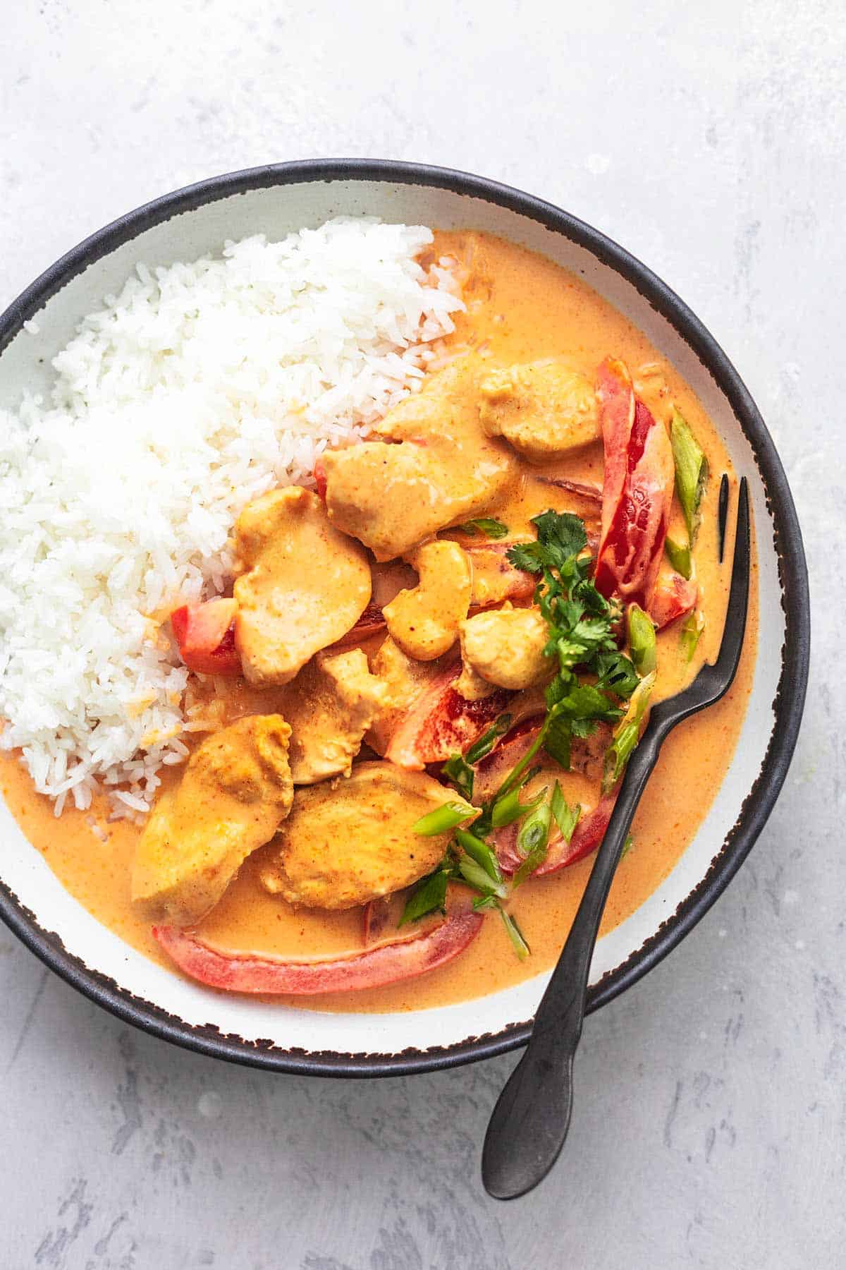 top view of Thai chicken curry with coconut milk with rice with a fork in a bowl.