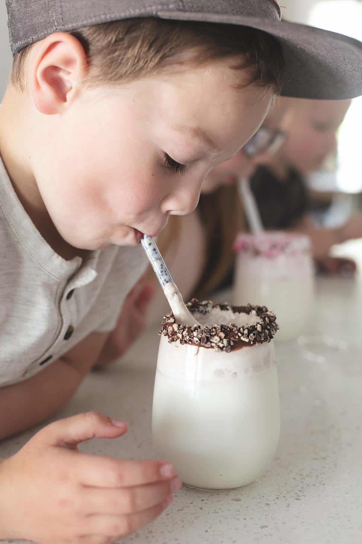 a row of kids drinking from straws whipped milk: three ways in glasses.