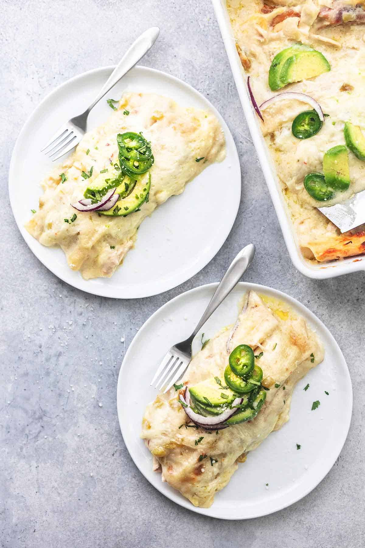 top view of two servings of enchiladas on plates and enchiladas in a pan.