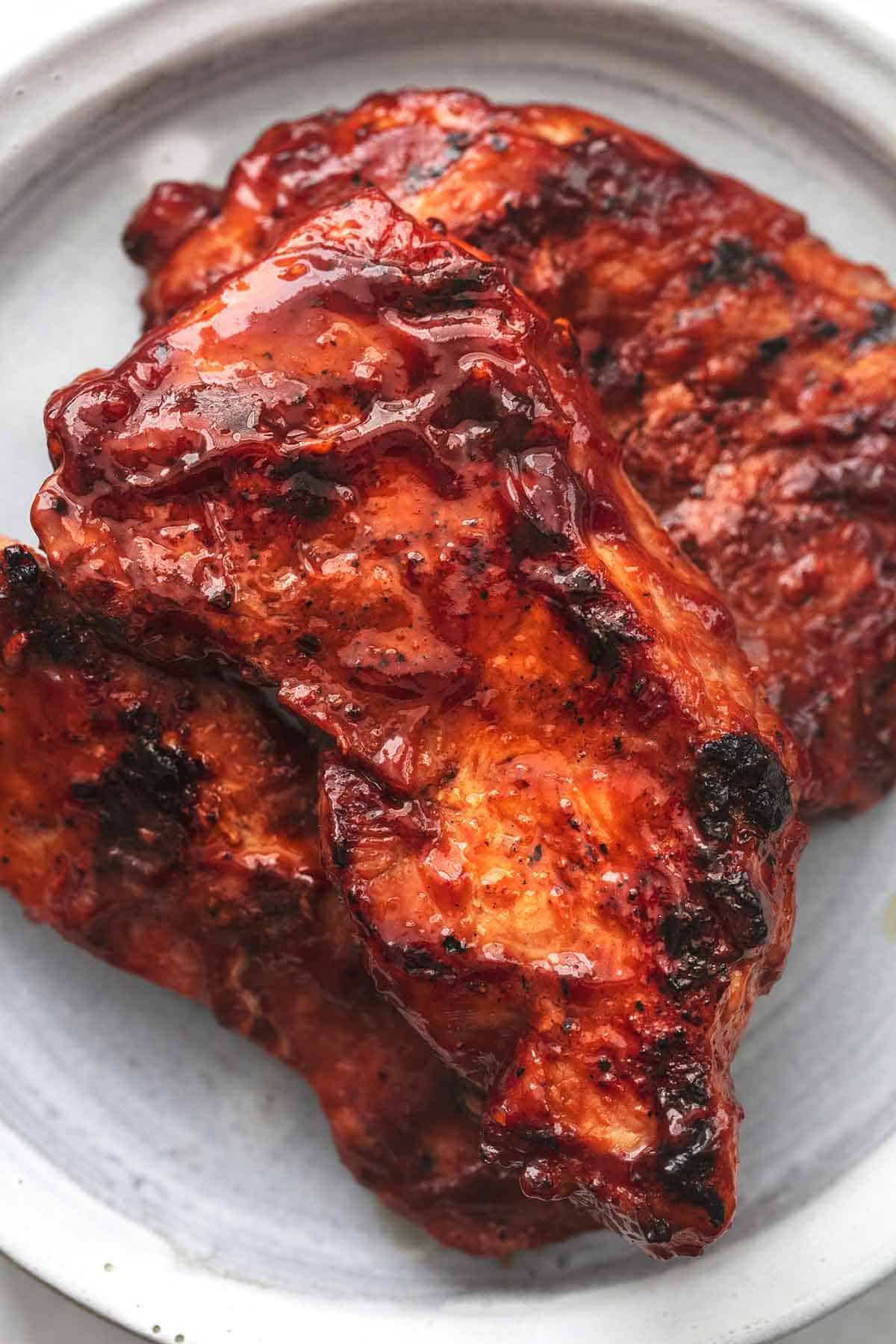 close up of grilled bbq pork chops on a plate.